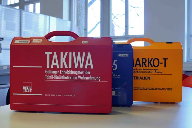 Auf dem Bild sind ein roter, ein blauer und ein gelber Koffer zu sehen.