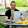 Das Bild zeigt einen Studenten. Er sitz im Innenhof der Hochschule. Er liest die aktuelle daktylos-Ausgabe. 