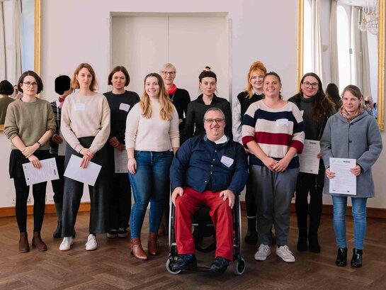 Das Foto zeigt eine Gruppe von Personen, welche alle in die Kamera lächeln.