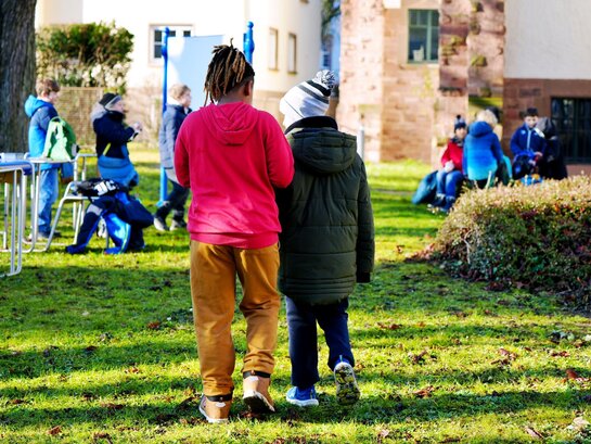 Das Foto zeigt zwei Kinder von hinten im Innenhof des Altbaus der PH HD.