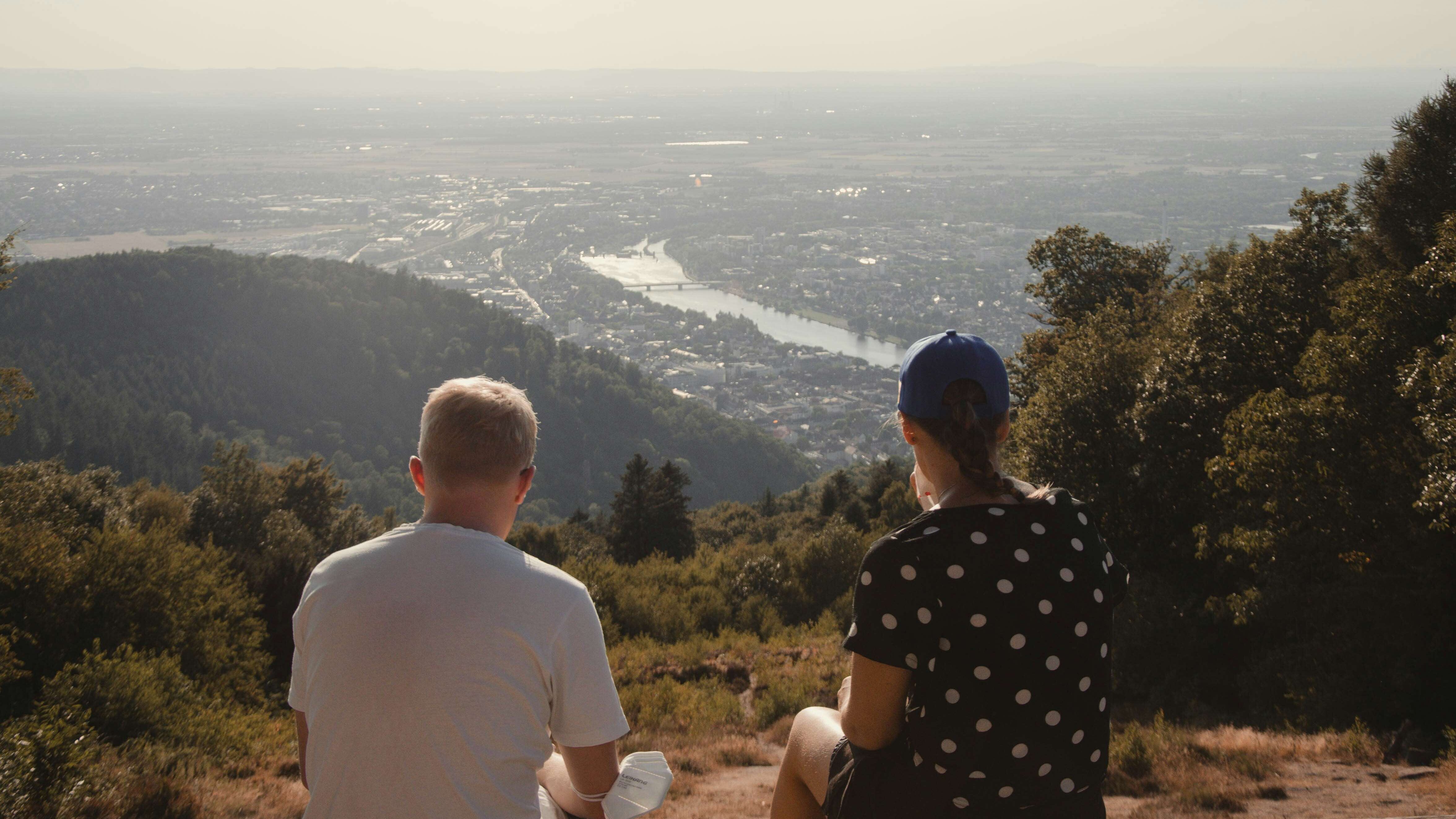 Zu sehen sind zwei Personen mit dem Heidelberger Panorama.