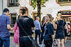 Mehrere Personen stehen im Innenhof des Altbaus und unterhalten sich.