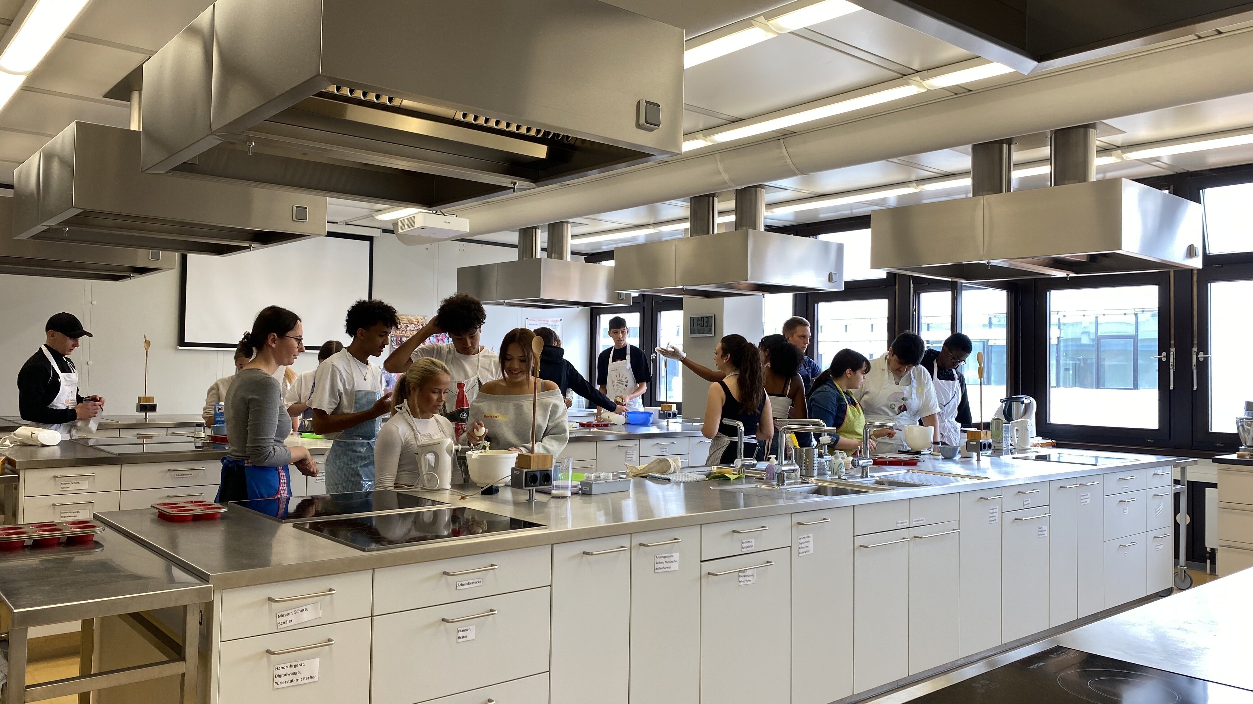 Seminar mit Schüler:innen in der Lehrküche der Alltagskultur und Gesundheit, wie sie Inhalte praxisorientiert anwenden.