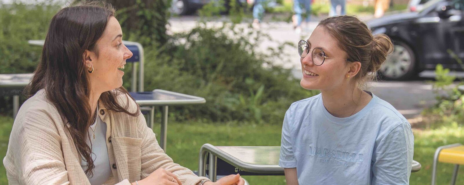 Zwei Studentinnen des Master Lehramt Grundschule der Pädagogischen Hochschule Heidelberg sitzen im Innenhof der Altbaus..