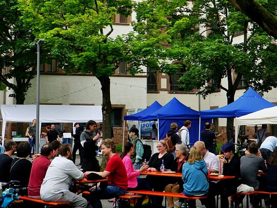 Menschen sitzen im festlichen geschmückten Innenhof der Alten PHHD.
