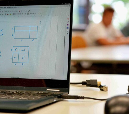 Zu sehen ist ein aufgeklappter Laptop.