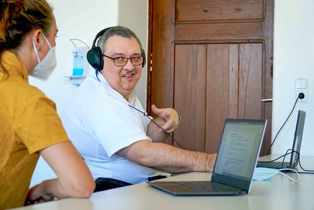 Das Bild zeigt Bildungsfachkraft Helmuth Pflantzer, der das von Svejy Woitt entwickelte Lernprogramm an seinem Laptop ausprobiert.