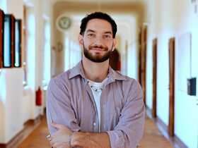 Porträtfoto von Tim Rossatti im Flur des Altbaus der Pädagogischen Hochschule Heidelberg.