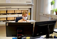 Das Symbolbild zeigt eine Mitarbeiterin des Studienbüros. Sie trägt wegen der Corona-Pandemie eine Maske. Copyright: Pädagogische Hochschule Heidelberg.