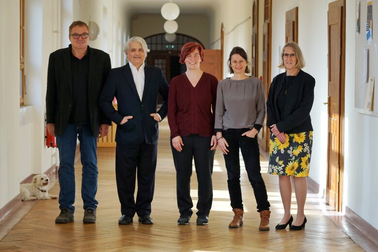 Das Foto zeigt fünf Personen stehend im Gang des Altbaus der PH.