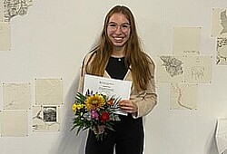 Das Bild zeigt Anna Morawietz. Sie hält die Auszeichnung sowie einen Blumenstrauß in der Hand. Sie strahlt in die Kamera. Copyright Pädagogische Hochschule Heidelberg