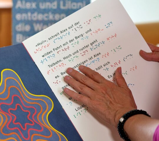 Das Bild fokussiert die Hand einer Person. Sie liest ein Buch in Brailleschrift.
