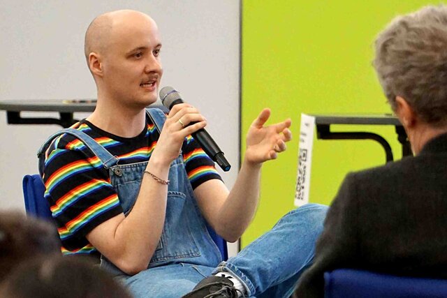 Zu sehen ist ein Sprecher in einer Diskussionsrunde.