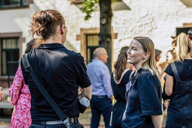 Zu sehen sind mehrere Personen im Gespräch.