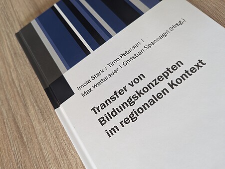 Das Bild zeigt ein Buchcover mit dem Titel "Transfer von Bildungskonzepten im regionalen Kontext"