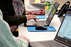 Das Foto zeigt schreibende Hände auf der Tastatur eines Laptops.