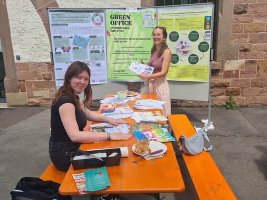 Zwei Mitglieder des Green Office der Pädagogischen Hochschule Heidelberg bieten einen Infostand im Garten des Altbaus an.