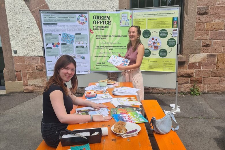 Zwei Mitglieder des Green Office der Pädagogischen Hochschule Heidelberg bieten einen Infostand im Garten des Altbaus an.