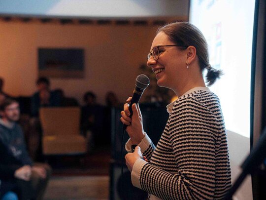 Zu sehen ist ein Forscher, der bei einem Science Slam einen Vortrag hält.