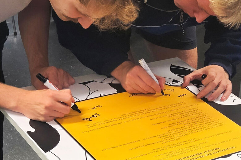 Zwei Studenten unterschreiben das Awareness-Statement.