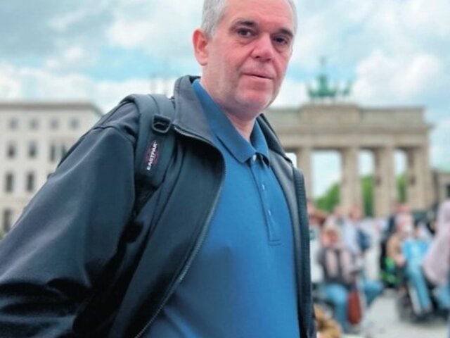 Das Bild zeigt Ottmar Miles-Paul vor dem Brandenburger Tor in Berlin