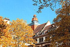 Das Symbolbild zeigt den Turm des Altbaus im Herbst.