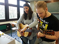 Studierende nehmen Gitarrenspiel mit Mikrofon auf