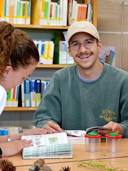 Zu sehen ist ein Student, der in die Kamera lächelt.