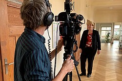 Das Bild zeigt im Vordergrund eine Person mit einer großen Videokamera. Und im Hintergrund ist Frau Terfloth zu erkennen. Copyright Pädagogische Hochschule Heidelberg