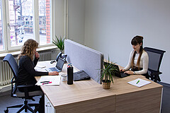 Das Symbolbild wurde im Transferzentrum der Hochschule aufgenommen. Es zeigt zwei Mitarbeiterinnen, die jeweils an ihrem Laptop sitzen und arbeiten. 