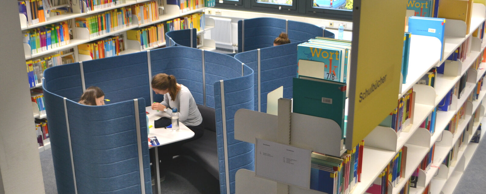 Das Bild zeigt eine Arbeitsinsel in der Bibliothek der PH Heidelberg.