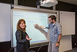 Das Bild zeigt zwei Menschen vor einer digitalen Tafel. Copyright Pädagogische Hochschule Heidelberg