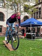 Person fährt mit einem Mountainbike über ein Hinderniss