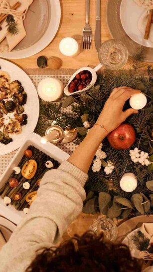 Ein festlich gedeckter Tisch mit Kerzen und Zweigen - ähnlich wie es PHeelGood für die Winterzeit für Studierende plant.