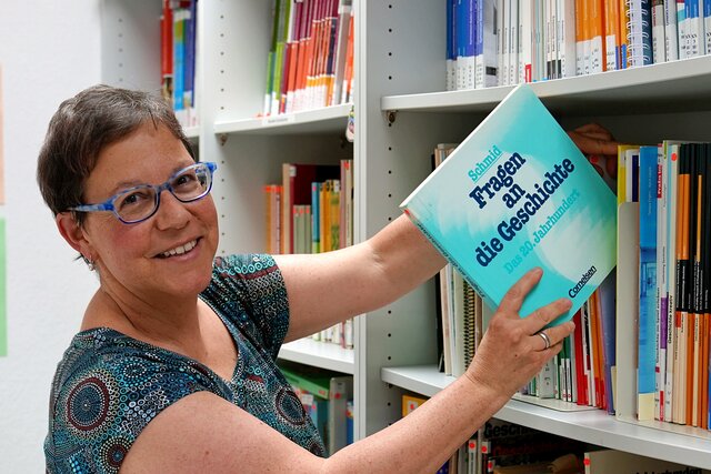 Foto einer Dozentin mit dem Schulbuch "Fragen an die Geschichte"