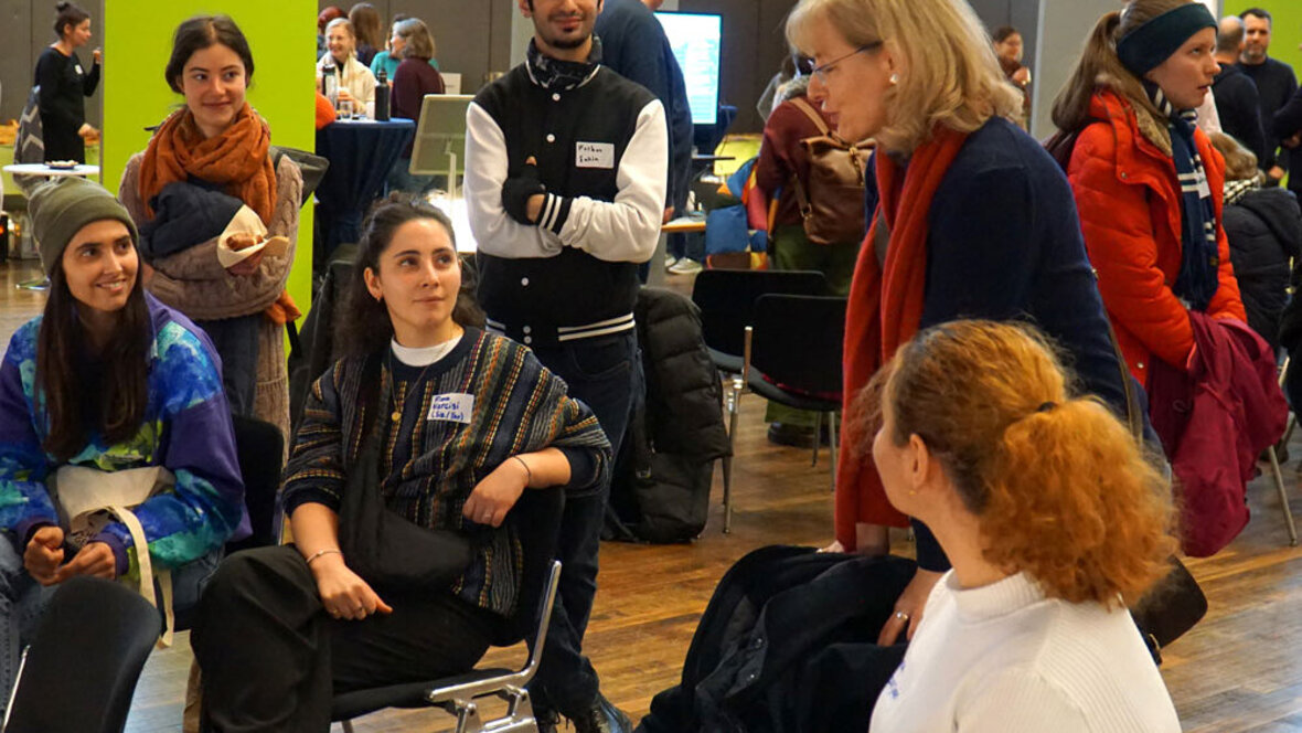 Ein Gruppe von Mitgliedern der Hochschule diskutiert in der Festhalle.