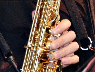 Hände auf einem Saxofon.