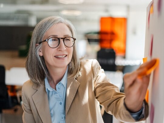 Person mittleren Alters vor Whiteboard in einer Weiterbildung an der PH Heidelberg, Fortbildung an der PH Heidelberg, hochschulische Weiterbildung, berufsbegleitend studieren