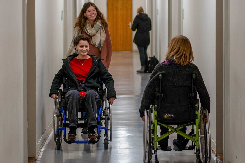 Das Bild zeigt Studentinnen, die im Rollstuhl sitzen und den Selbsterfahrungsparcours mitmachen.