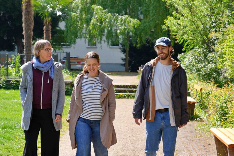 zwei Frauen und ein mann laufen der Kamera entgegen