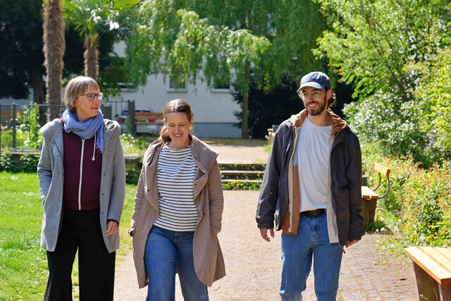 zwei Frauen und ein mann laufen der Kamera entgegen