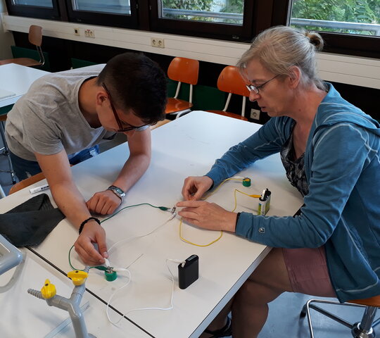 Ein Mann und eine Frau experimentieren mit einem elektronischen Schaltkreis