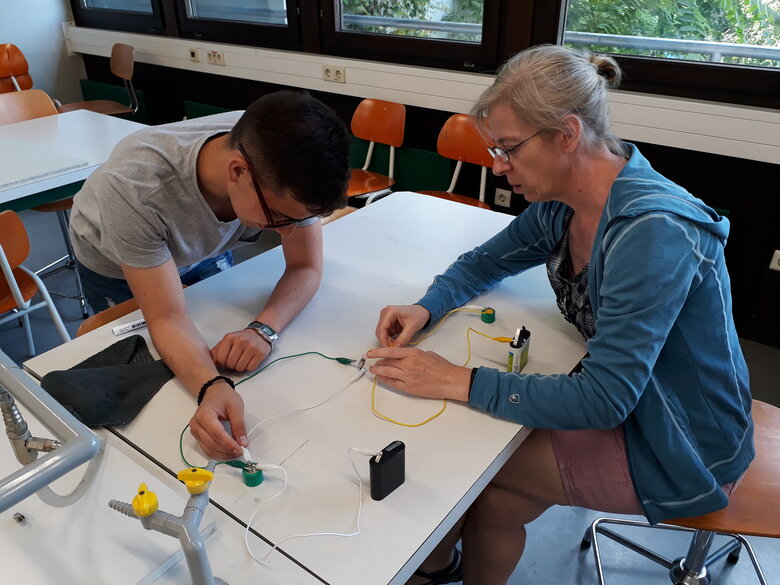 Ein Mann und eine Frau experimentieren mit einem elektronischen Schaltkreis