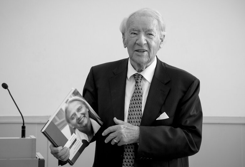 Porträt von Jobst Wellensiek. Er hält die Gedenkschrift an seine Frau Anneliese Wellensiek in der Hand.