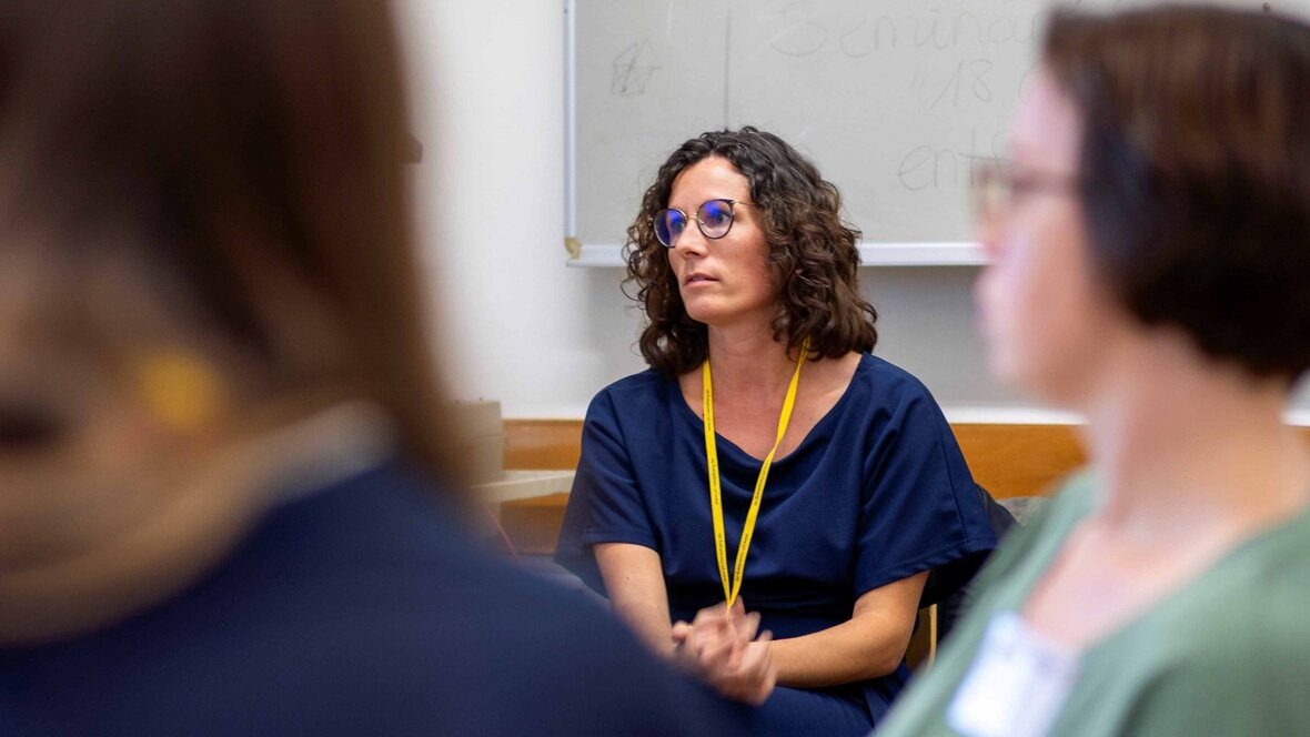 Das Bild zeigt Christina Mechler, die einen Tagungsbeitrag verfolgt.