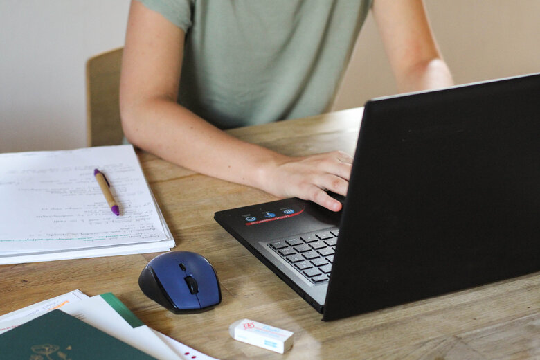 Das Symbolbild zeigt eine Person, die am Laptop arbeitet. Man sieht das Gesicht der Person nicht. Copyright: PH Heidelberg.