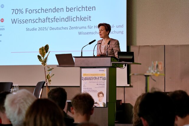 Zu sehen ist Frau Prof. Dr. med. Dr. Eva Winkler während ihres Vortrages am Rednerpult stehend.