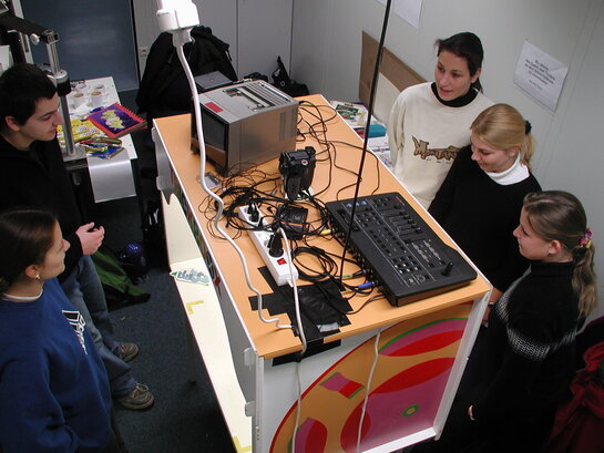 Fünf Studenten sitzen um eine Trickbox und betrachten eine neue Animation.