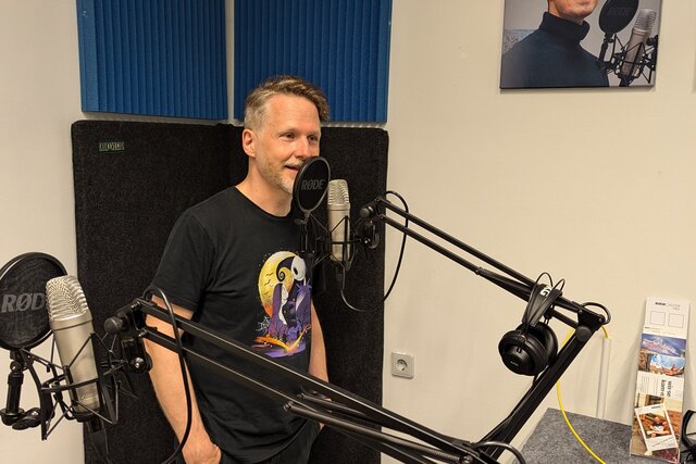 Zu sehen ist Christian Spannagel am Mikrofon im Podcast-Studio.