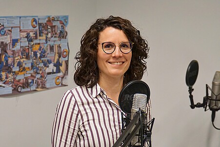 Zu sehen ist eine Frau, Christina Mechler, am Mikrofon im Podcast-Studio